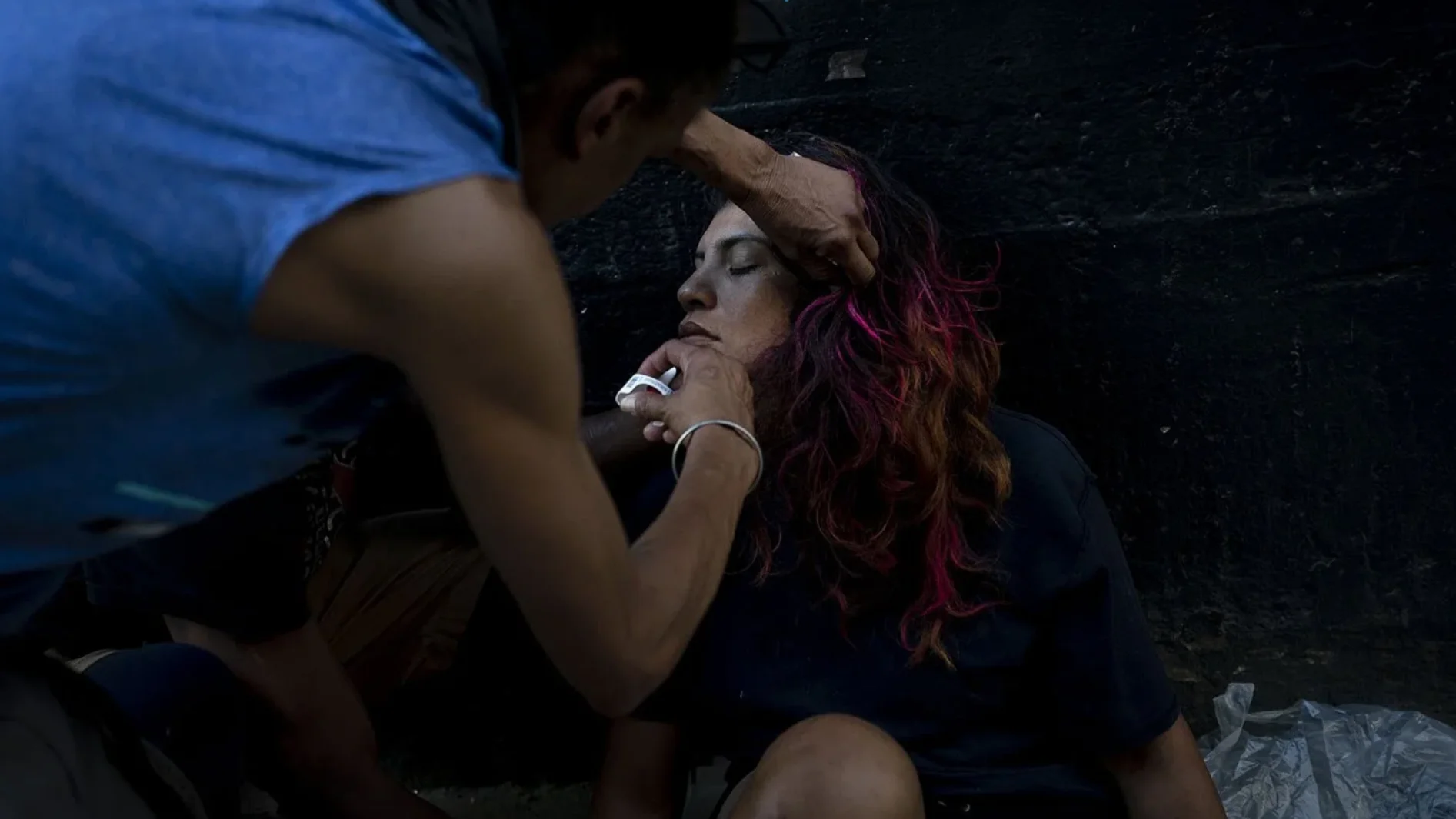 Homem em situação de rua aplica Narcan, medicamento em spray nasal utilizado para reverter overdoses por opioides, em uma mulher com suspeita de overdose em Los Angeles, nos Estados Unidos, em 25 de agosto de 2022. Foto: Jae C. Hong/AP.