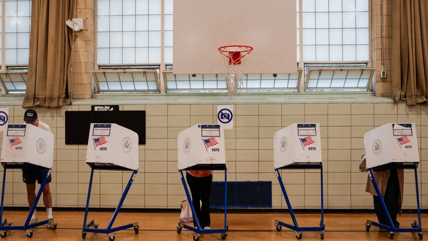 Eleitores em cabines de votação montadas em um ginásio nos Estados Unidos